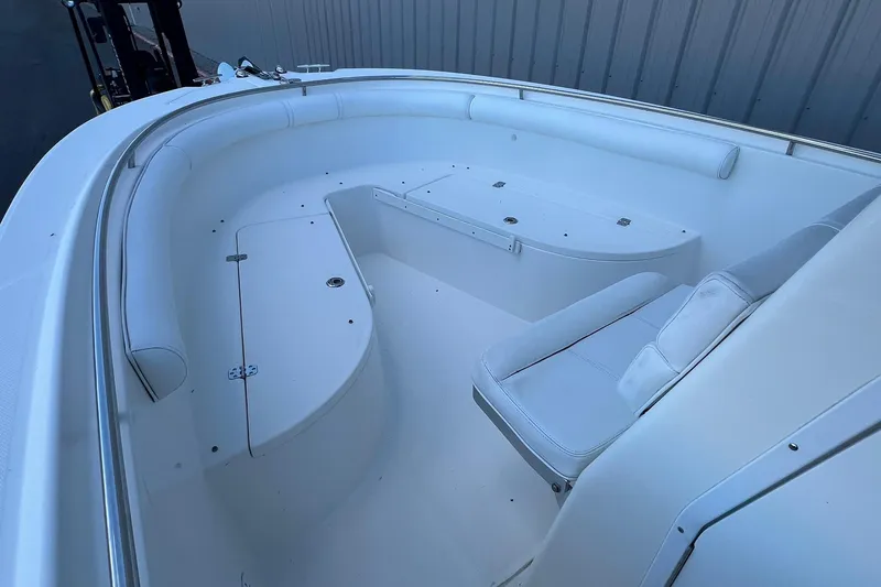 Slide: The Image of 2006 Edgewater 245CC boat interior with white seating and storage compartments. - 6