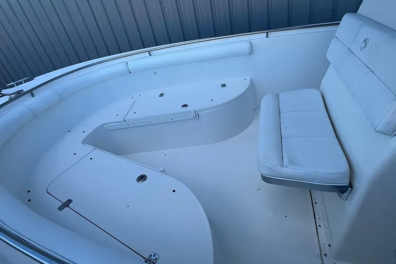 Slide: The Image of Interior of a 2006 Edgewater 245CC boat, featuring white seating and storage compartments. - 7