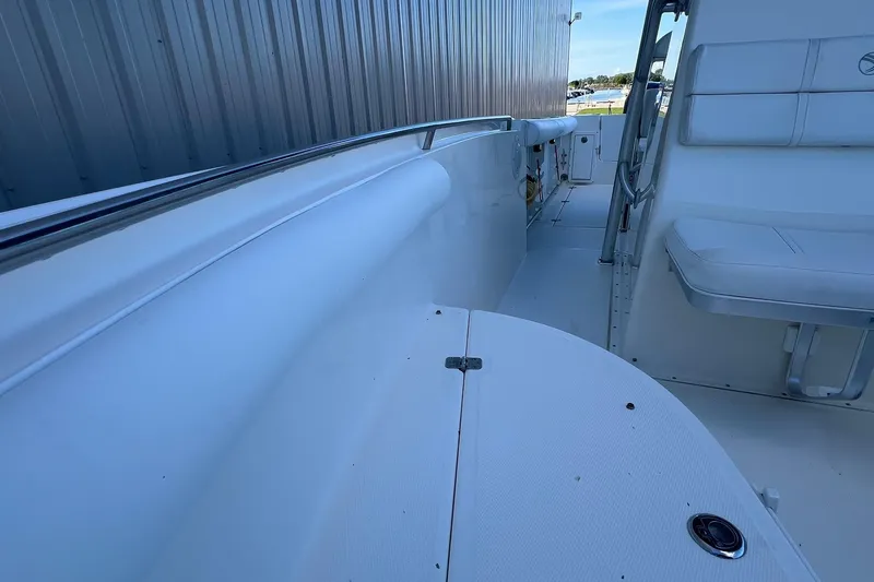 Slide: The Image of 2006 Edgewater 245CC boat interior with white seating and stainless steel railing. - 8