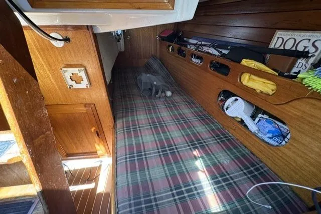 Slide: The Image of Interior of a 1977 Ericson 35 sailboat with plaid bedding and wooden storage compartments. - 12