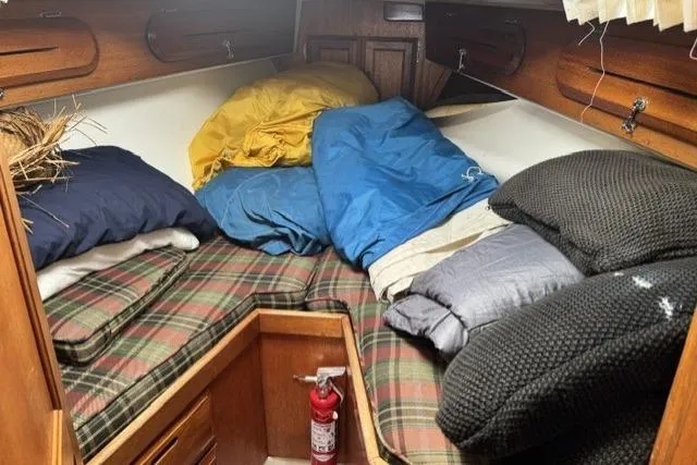 Slide: The Image of Cozy cabin interior of a 1977 Ericson 35 sailboat with plaid cushions and colorful bedding. - 16
