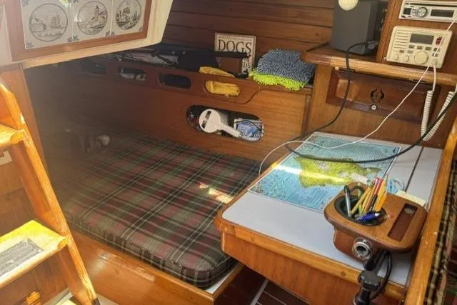 Slide: The Image of Cozy 1977 Ericson 35 sailboat cabin with plaid bedding and navigation table. - 19