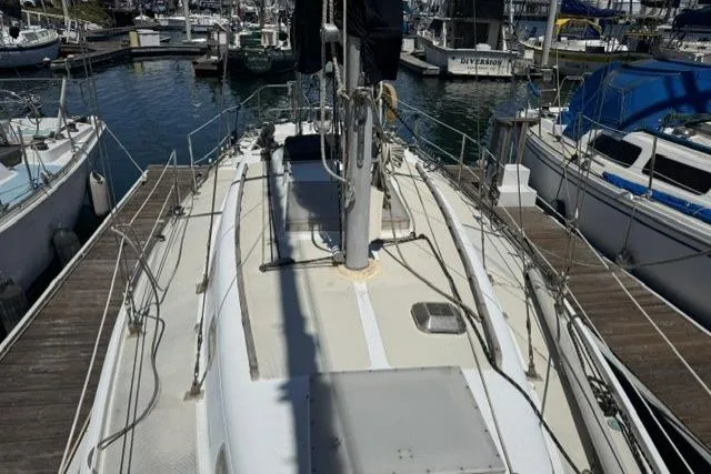 Slide: The Image of 1977 Ericson 35 sailboat docked at marina, showcasing deck and rigging. - 2