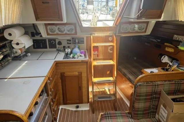 Slide: The Image of Interior of a 1977 Ericson 35 sailboat with wooden cabinetry and plaid seating. - 21