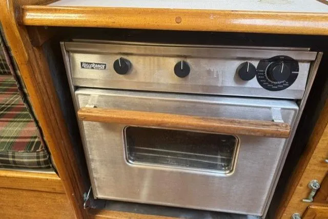 Slide: The Image of Vintage 1977 Ericson 35 sailboat galley with a stainless steel oven and wooden accents. - 22