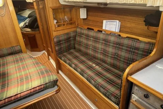 Slide: The Image of 1977 Ericson 35 sailboat interior with plaid seating and wooden finishes. - 23