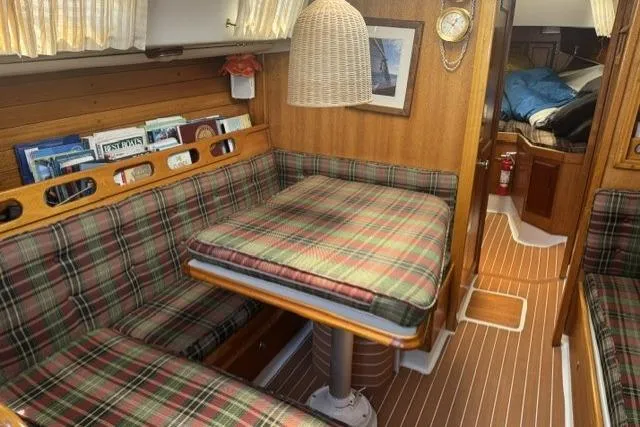 Slide: The Image of 1977 Ericson 35 sailboat interior with plaid seating, wooden accents, and nautical decor. - 24