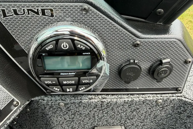 Slide: The Image of Control panel of 2027 Lund 1675 Adventure Sport boat with audio system and power outlets. - 14