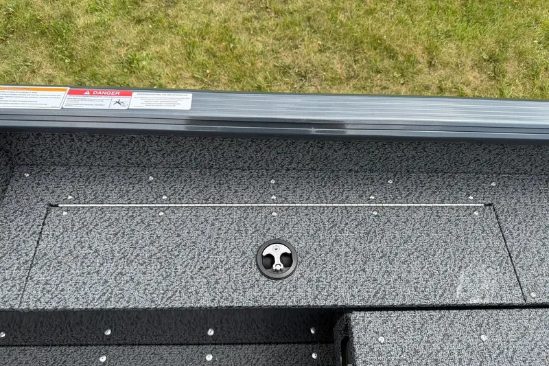 Slide: The Image of 2027 Lund 1675 Adventure Sport boat interior with textured flooring and safety labels. - 18