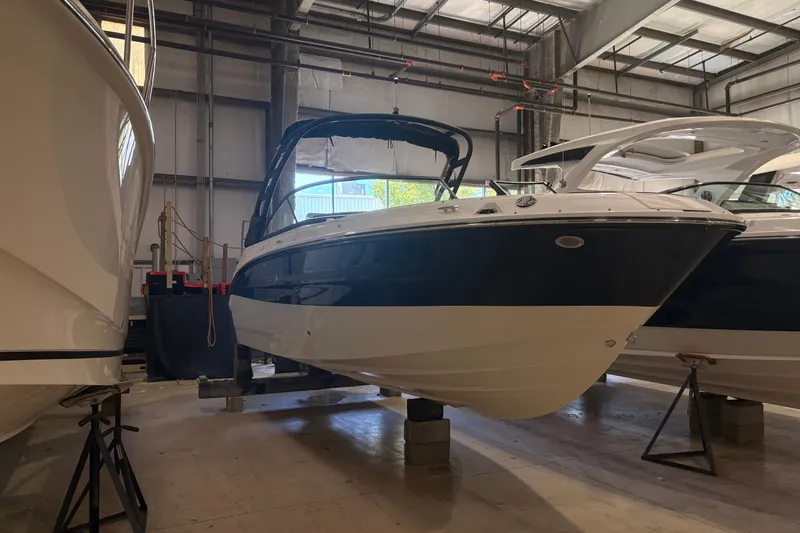 The Image of 2026 Sea Ray SDX 250 Surf boat in indoor storage facility. - 1