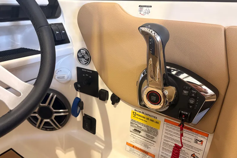 Slide: The Image of 2026 Sea Ray SDX 250 Surf boat control panel with steering wheel and throttle lever. - 13