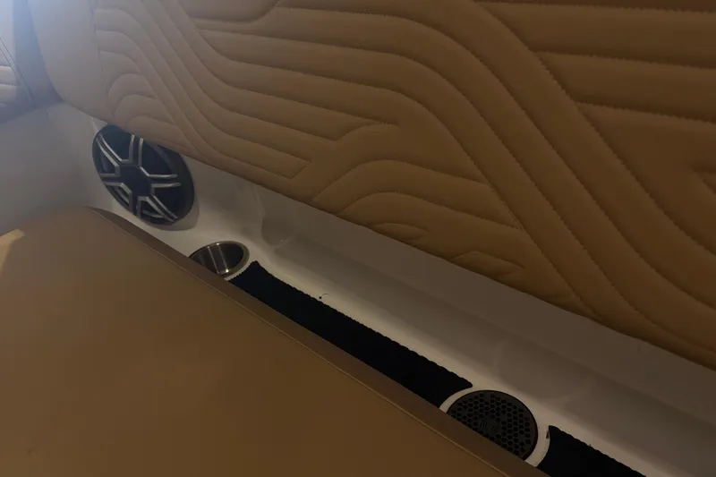 Slide: The Image of Interior of 2026 Sea Ray SDX 250 Surf boat with tan upholstery and speaker system. - 14