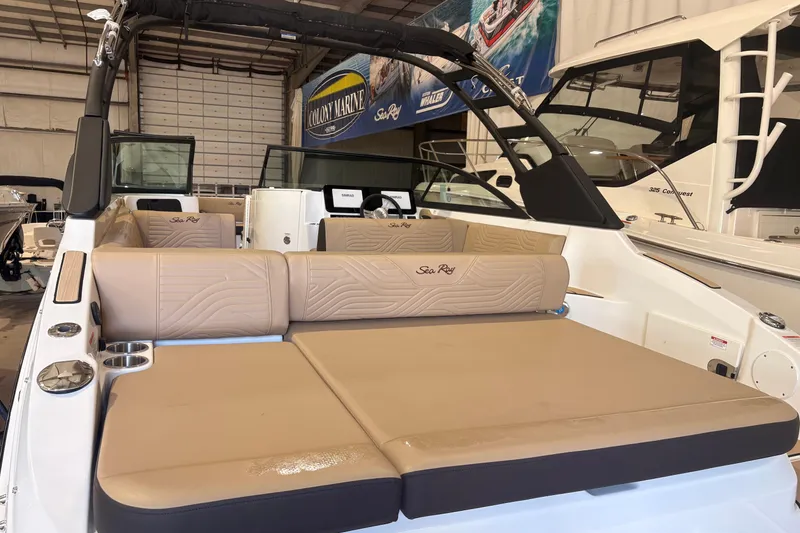 Slide: The Image of 2026 Sea Ray SDX 250 Surf boat interior with tan seating in a showroom. - 18