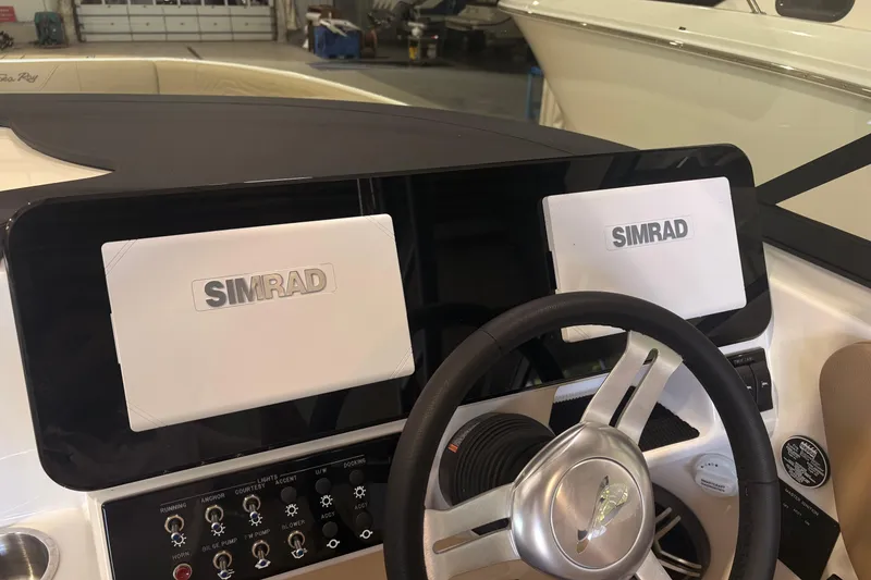 Slide: The Image of 2026 Sea Ray SDX 250 Surf dashboard with Simrad displays and steering wheel. - 20