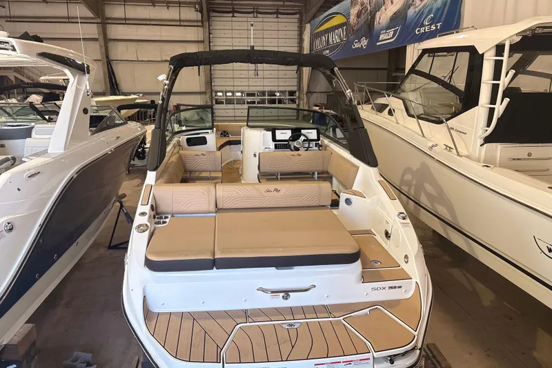 Slide: The Image of 2026 Sea Ray SDX 250 Surf boat in showroom, featuring spacious seating and modern design. - 3