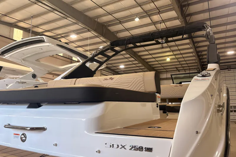 Slide: The Image of 2026 Sea Ray SDX 250 Surf boat in showroom, showcasing sleek design and luxurious seating. - 4