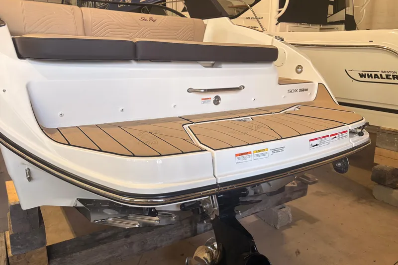 Slide: The Image of 2026 Sea Ray SDX 250 Surf boat with teak swim platform in showroom. - 6