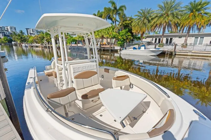 Slide: The Image of 2017 Robalo R222 Center Console boat docked on a scenic canal with palm trees. - 23