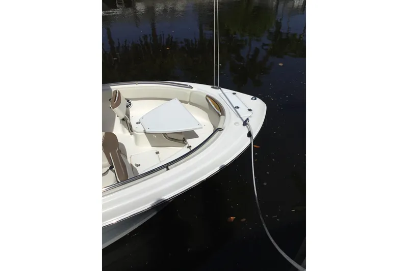Slide: The Image of 2017 Robalo R222 Center Console boat docked on calm water. - 2