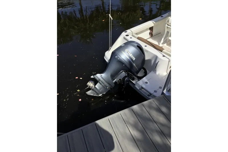 Slide: The Image of 2017 Robalo R222 Center Console with Yamaha outboard motor docked by water. - 9