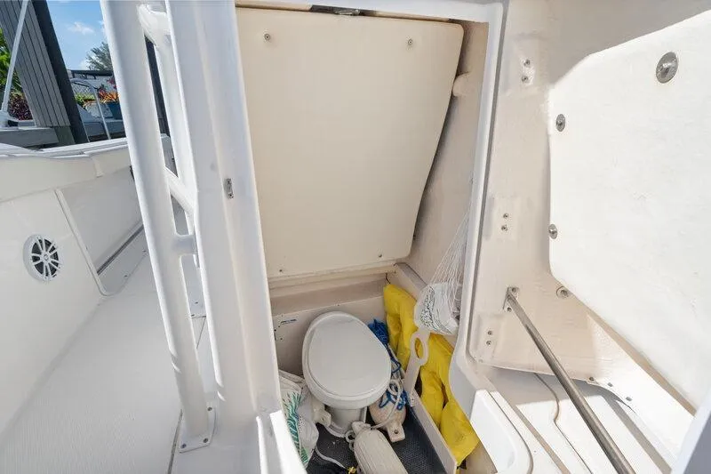 Slide: The Image of 2017 Robalo R222 Center Console boat interior with storage and marine toilet. - 24
