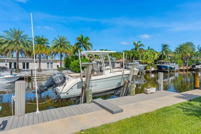 Slide: The Image of 2017 Robalo R222 Center Console boat docked by a scenic waterfront. - 22