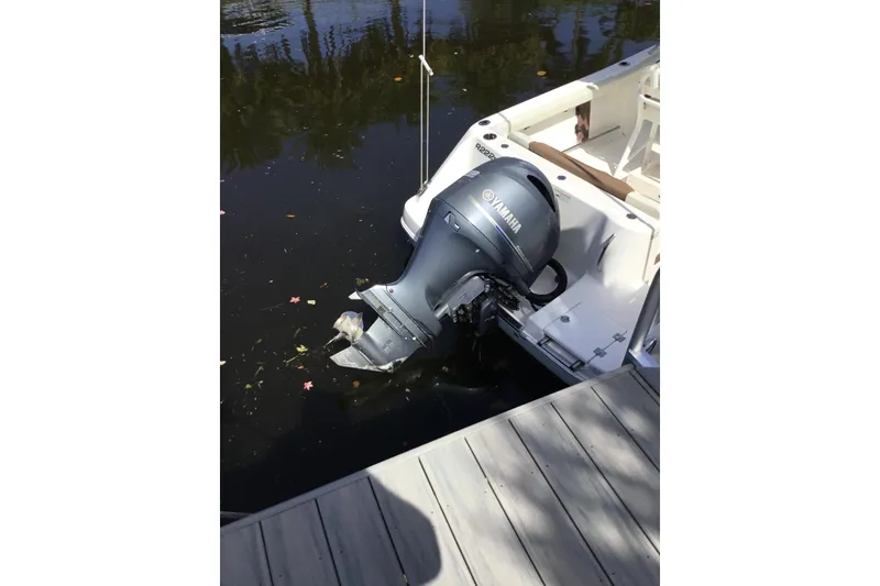 Slide: The Image of 2017 Robalo R222 Center Console with Yamaha outboard motor docked by water. - 8