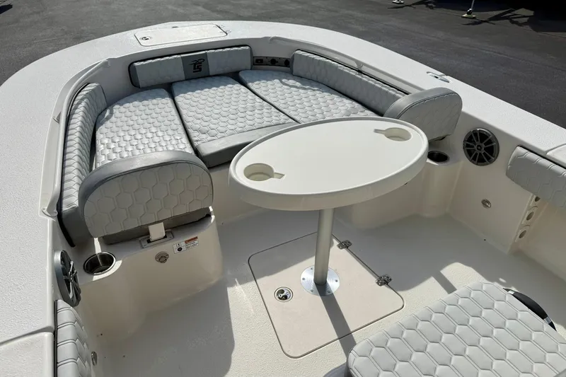 Slide: The Image of 2026 Carolina Skiff 24 Ultra Elite boat interior with cushioned seating and round table. - 12