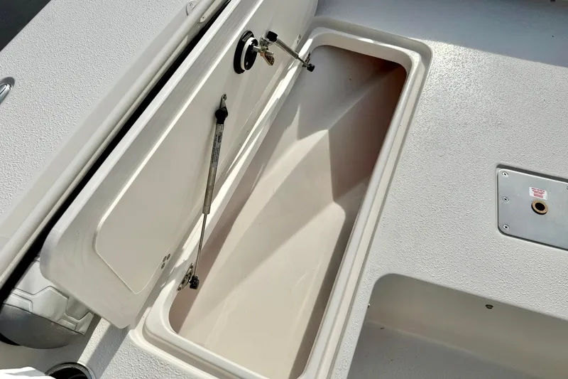 Slide: The Image of Open storage compartment on 2026 Carolina Skiff 24 Ultra Elite boat deck. - 15