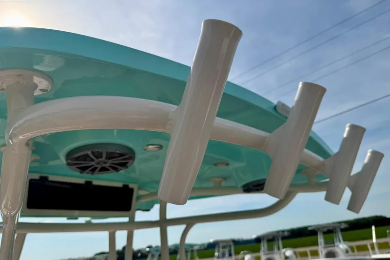 Slide: The Image of 2026 Carolina Skiff 24 Ultra Elite boat with rod holders and speakers under a blue sky. - 28
