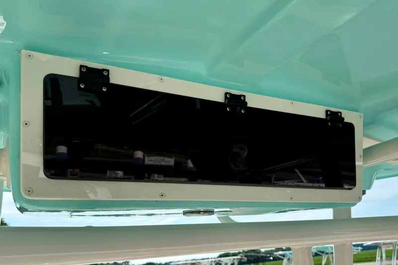 Slide: The Image of 2026 Carolina Skiff 24 Ultra Elite boat storage compartment with sleek black panel. - 30