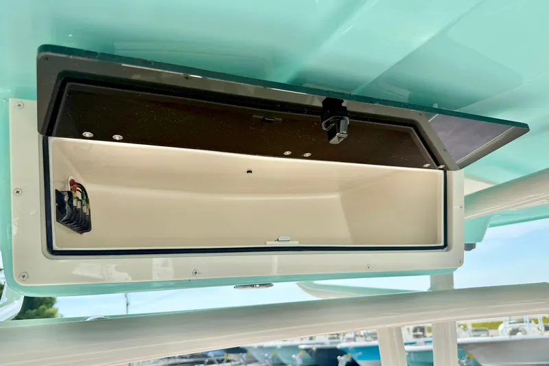 Slide: The Image of 2026 Carolina Skiff 24 Ultra Elite storage compartment, open and empty, with visible wiring. - 31