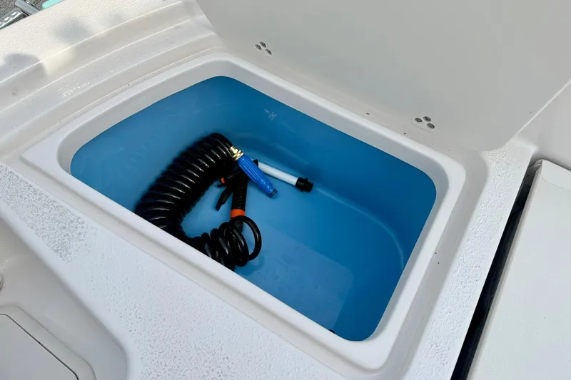 Slide: The Image of Storage compartment with coiled hose on 2026 Carolina Skiff 24 Ultra Elite boat. - 38