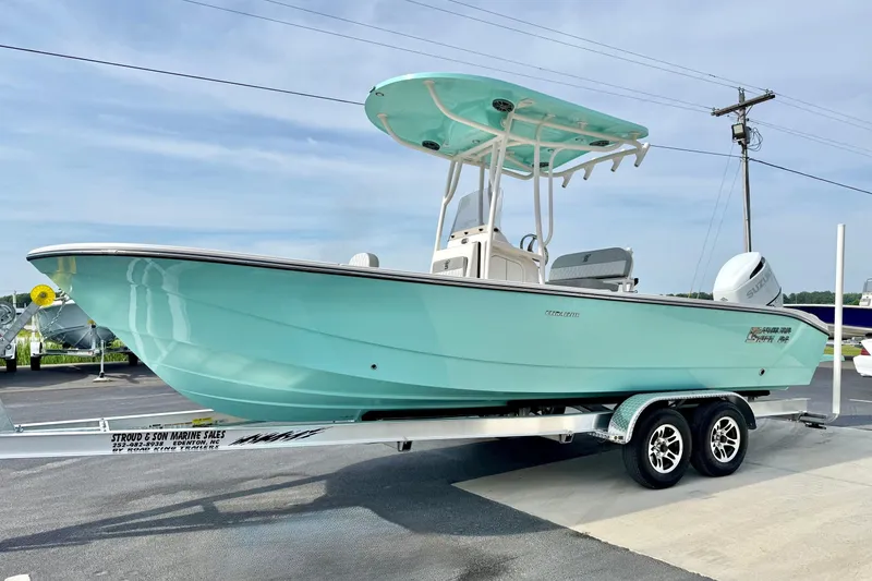 Slide: The Image of 2026 Carolina Skiff 24 Ultra Elite boat on trailer, light blue hull, outdoor display. - 5