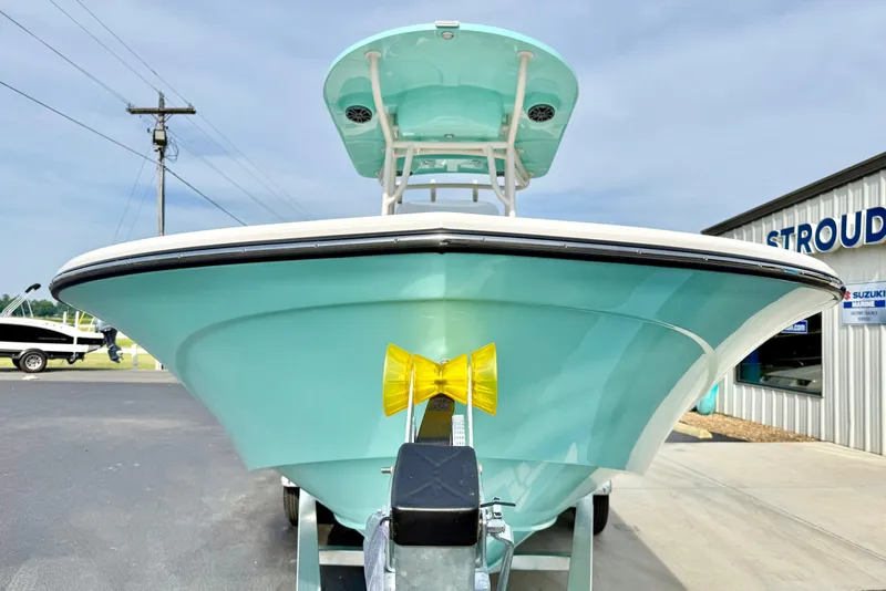 Slide: The Image of 2026 Carolina Skiff 24 Ultra Elite boat in light blue, displayed outdoors at a dealership. - 8