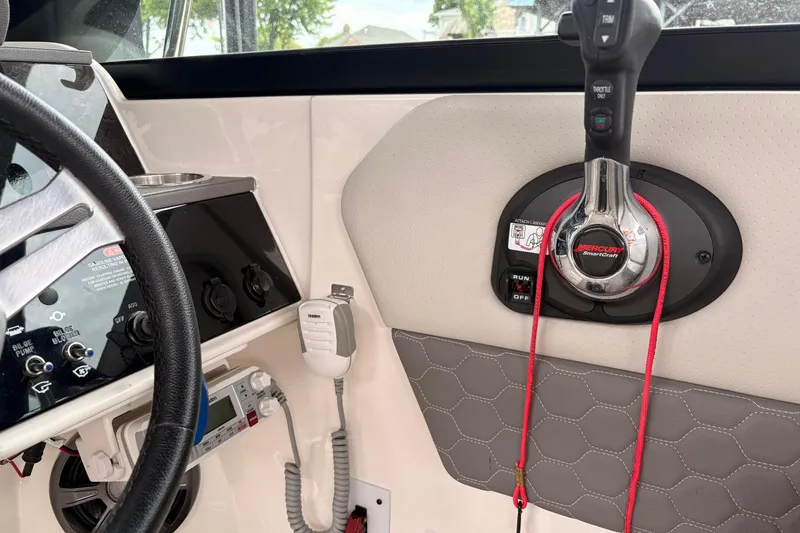 Slide: The Image of Interior of a 2021 Sea Ray SDX 250 boat showing steering and control panel. - 13