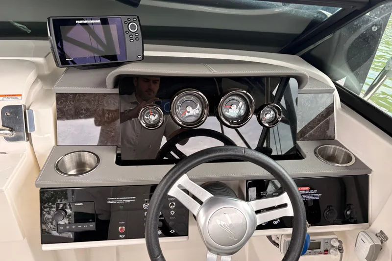 Slide: The Image of 2021 Sea Ray SDX 250 dashboard with steering wheel, gauges, and navigation system. - 15
