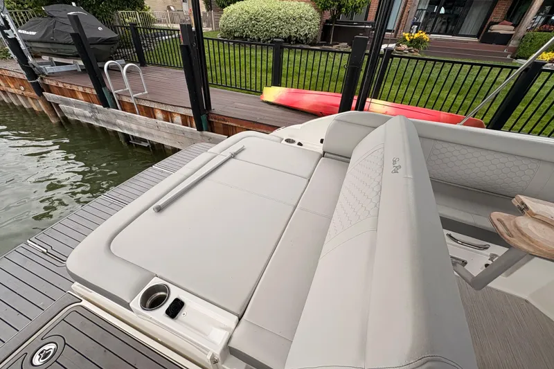 Slide: The Image of 2021 Sea Ray SDX 250 boat with spacious seating, docked near a waterfront home. - 20