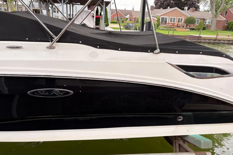 Slide: The Image of 2021 Sea Ray SDX 250 boat docked, featuring sleek black and white design. - 3