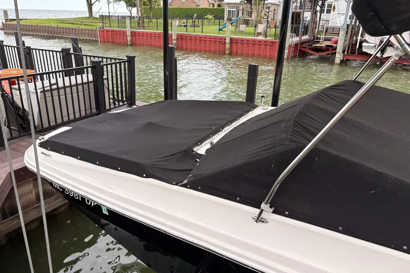Slide: The Image of 2021 Sea Ray SDX 250 boat with black cover docked by waterfront. - 5