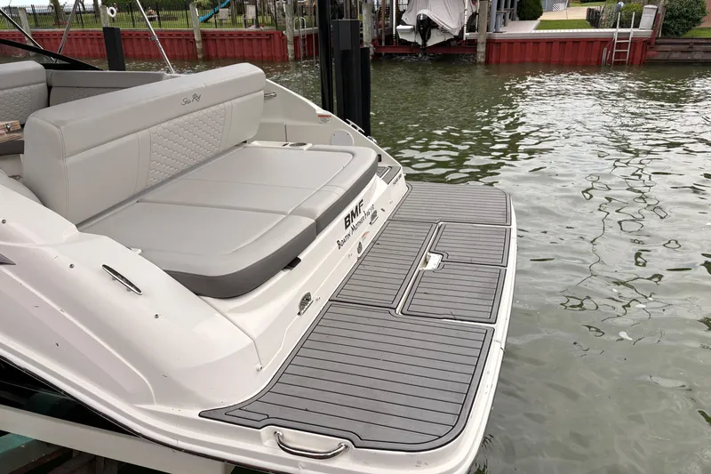 Slide: The Image of 2021 Sea Ray SDX 250 boat with spacious rear seating and swim platform by the water. - 7