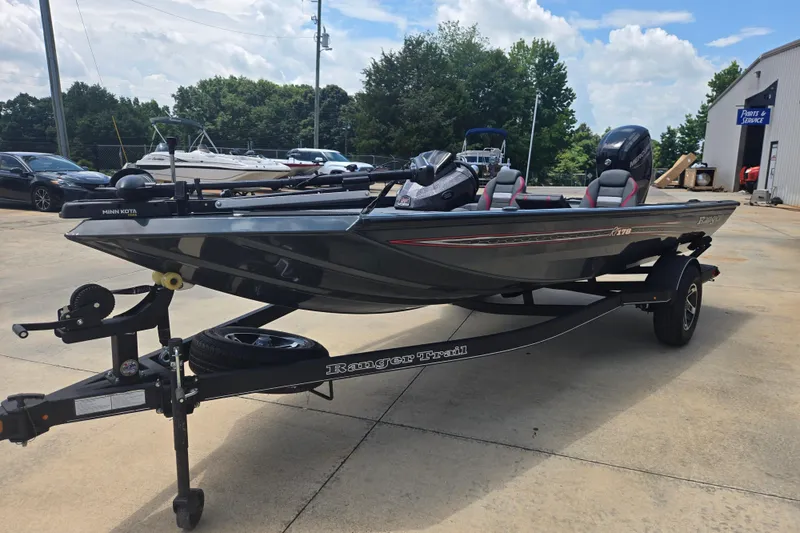 Slide: The Image of 2023 Ranger RT178 fishing boat on trailer, parked outdoors, with Minn Kota trolling motor. - 2