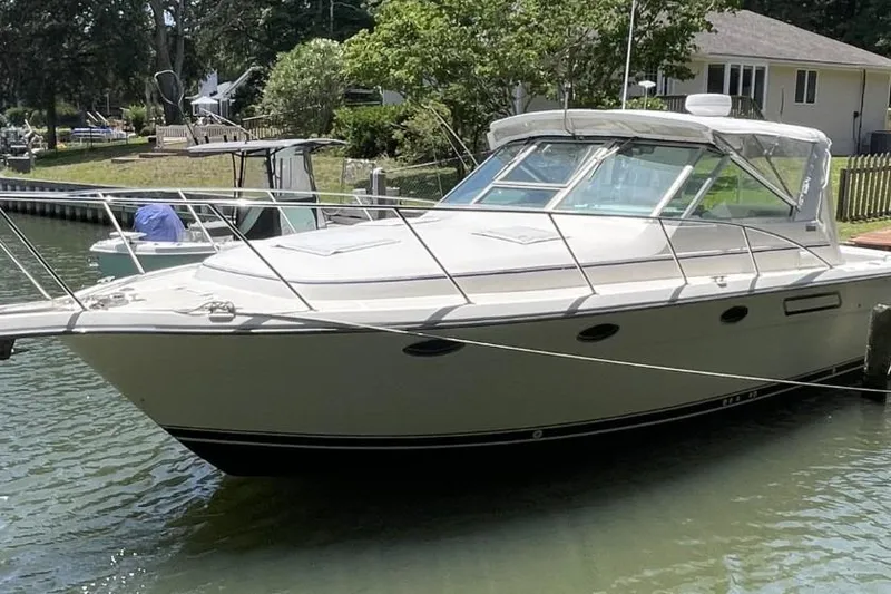 The Image of 1997 Tiara Yachts 3100 Open docked in a serene waterfront setting. - 0
