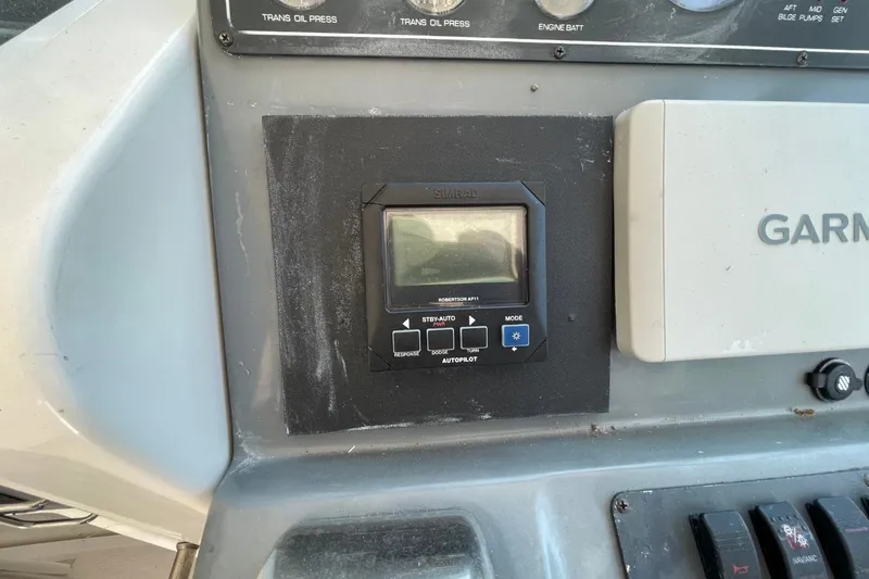 Slide: The Image of 1997 Tiara Yachts 3100 Open dashboard with Simrad autopilot and Garmin navigation system. - 14