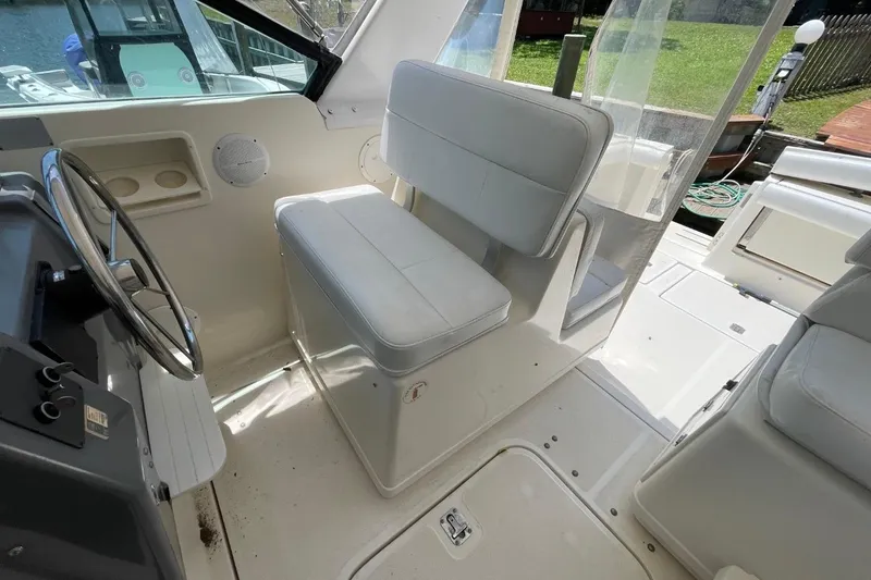 Slide: The Image of 1997 Tiara Yachts 3100 Open interior with white seating and steering wheel. - 16