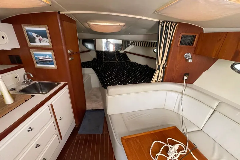 Slide: The Image of Interior of a 1997 Tiara Yachts 3100 Open, featuring a cozy cabin layout. - 19