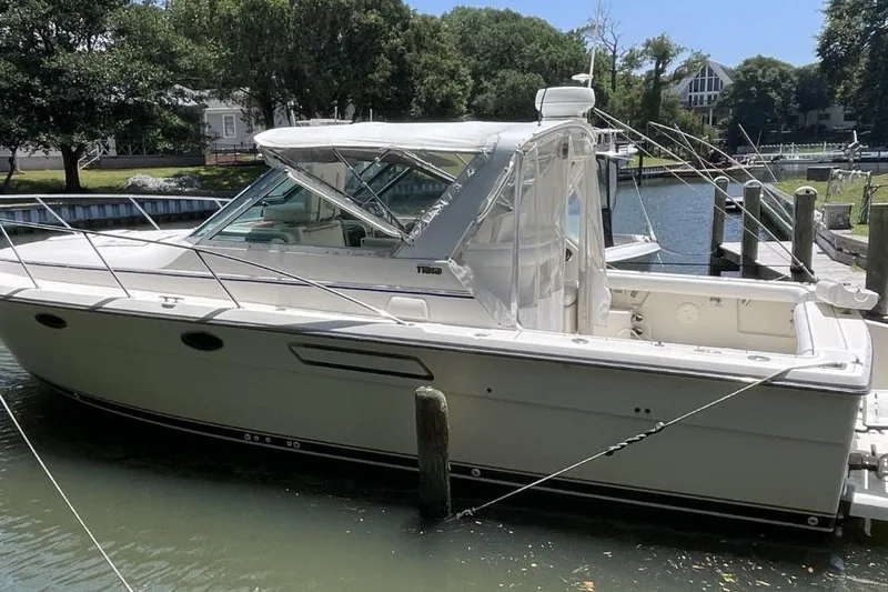 Slide: The Image of 1997 Tiara Yachts 3100 Open docked in a serene marina setting. - 2