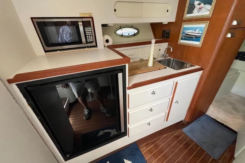 Slide: The Image of 1997 Tiara Yachts 3100 Open galley with microwave, sink, and storage cabinets. - 21