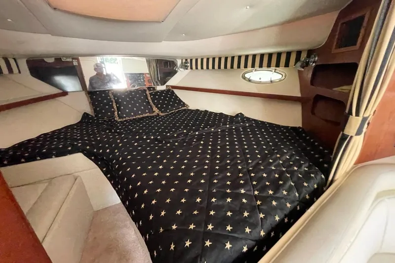 Slide: The Image of Interior cabin of 1997 Tiara Yachts 3100 Open with star-patterned bedding. - 23