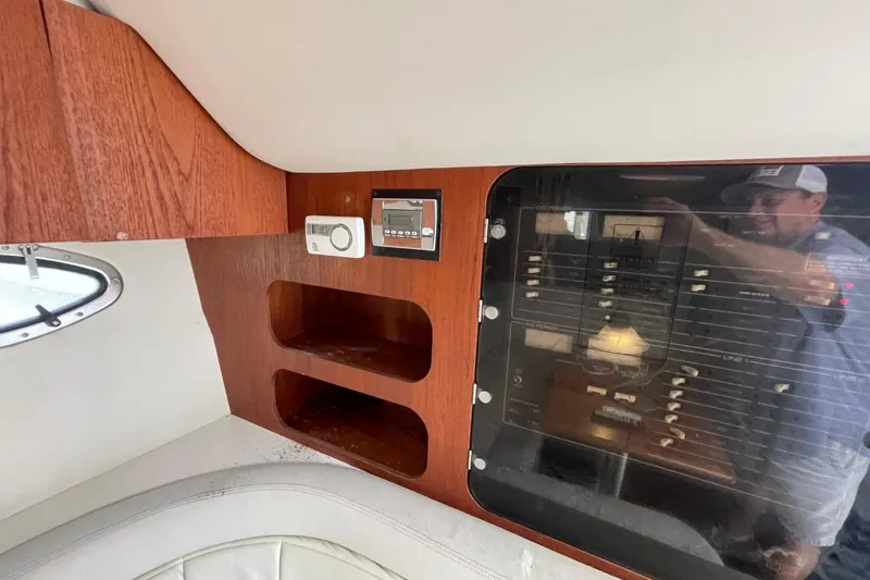 Slide: The Image of 1997 Tiara Yachts 3100 Open interior with control panel and wooden shelving. - 24